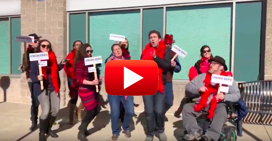 Denver Streets Partnership members dance and lip sync with Vision Zero signs and feather boas