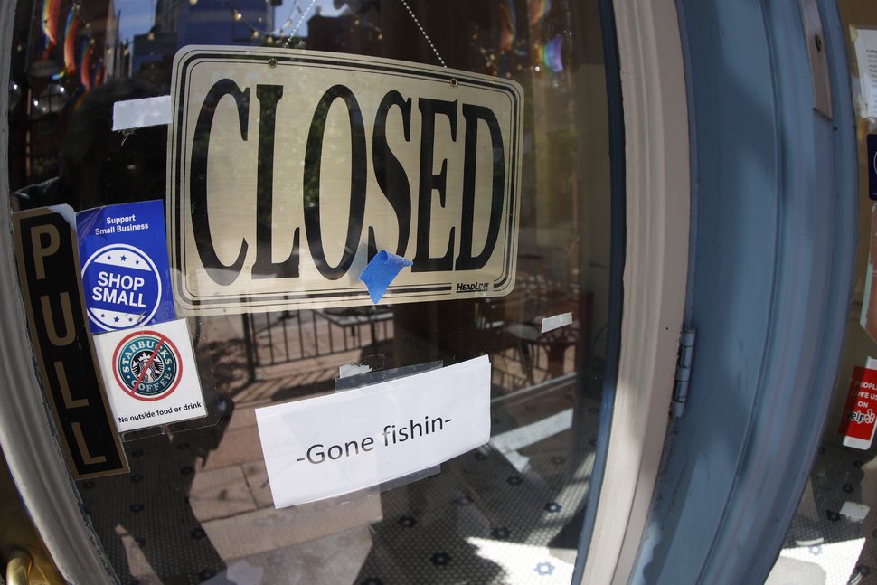 A closed sign hangs in the door a restaurant and food store in downtown Denver, on June 18. DAVID ZALUBOWSKI/AP