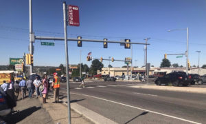 A bus stop just south of 54th Ave is located along a narrow sidewalk between a parking lot and fast-moving traffic on Federal. No bench or shelter is present to make the wait in the 95-degree heat more comfortable.