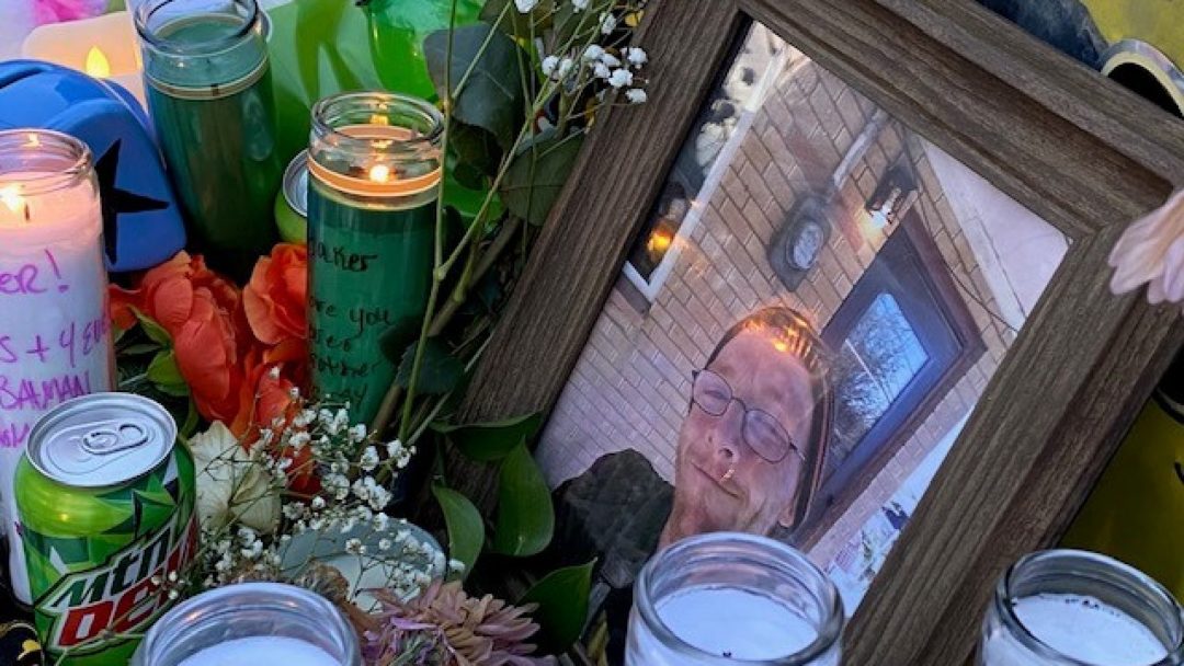 Framed photo of Chris Baker, candles, flowers, notes 01-23-2021 - Credit KMGH Denver7