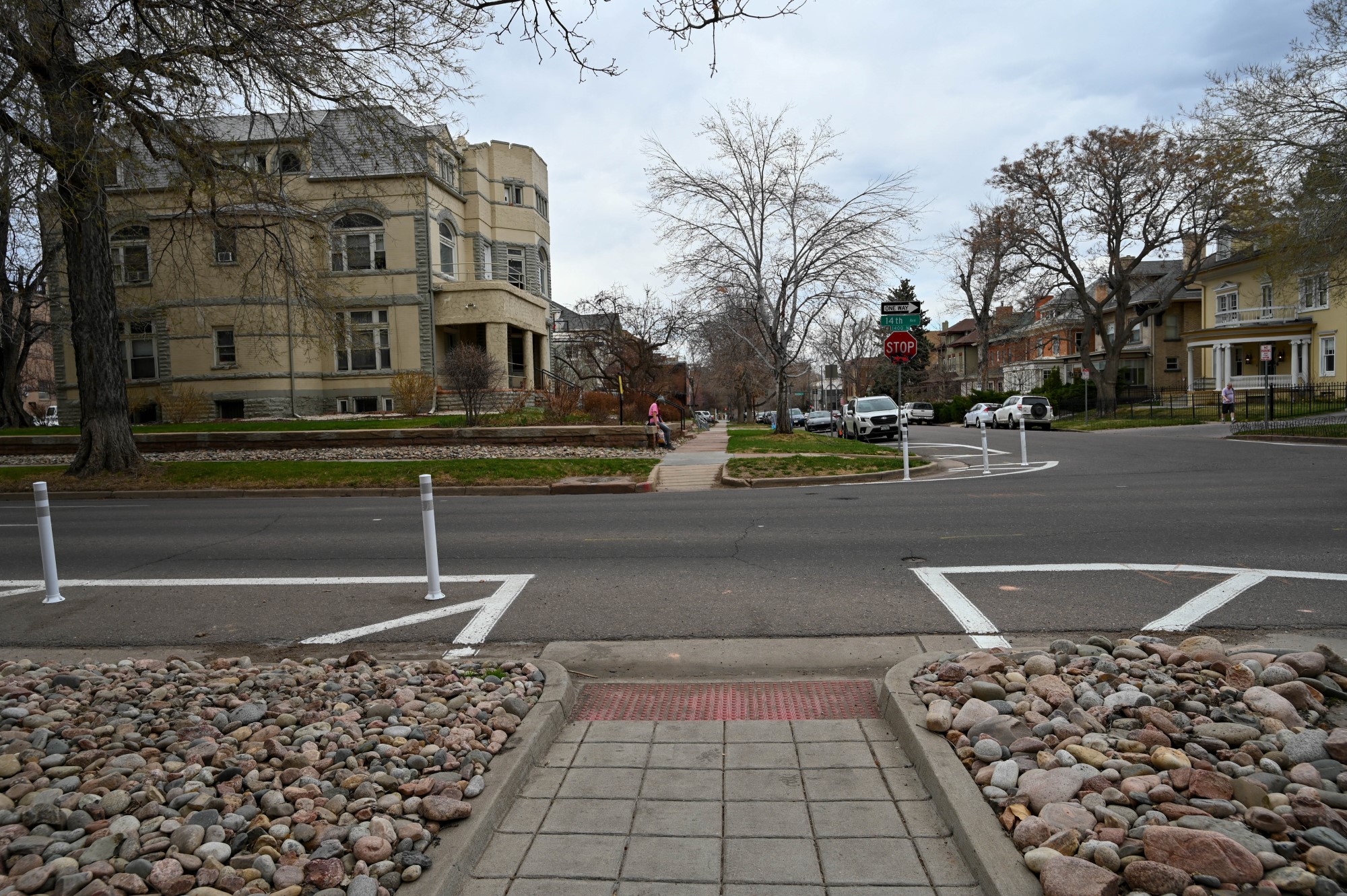 An unmarked crosswalk flanked by painted bulbout curb extension.
