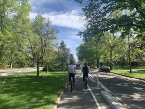 POV on a bikeway with bicyclists moving ahead on a sunny day in Denver.