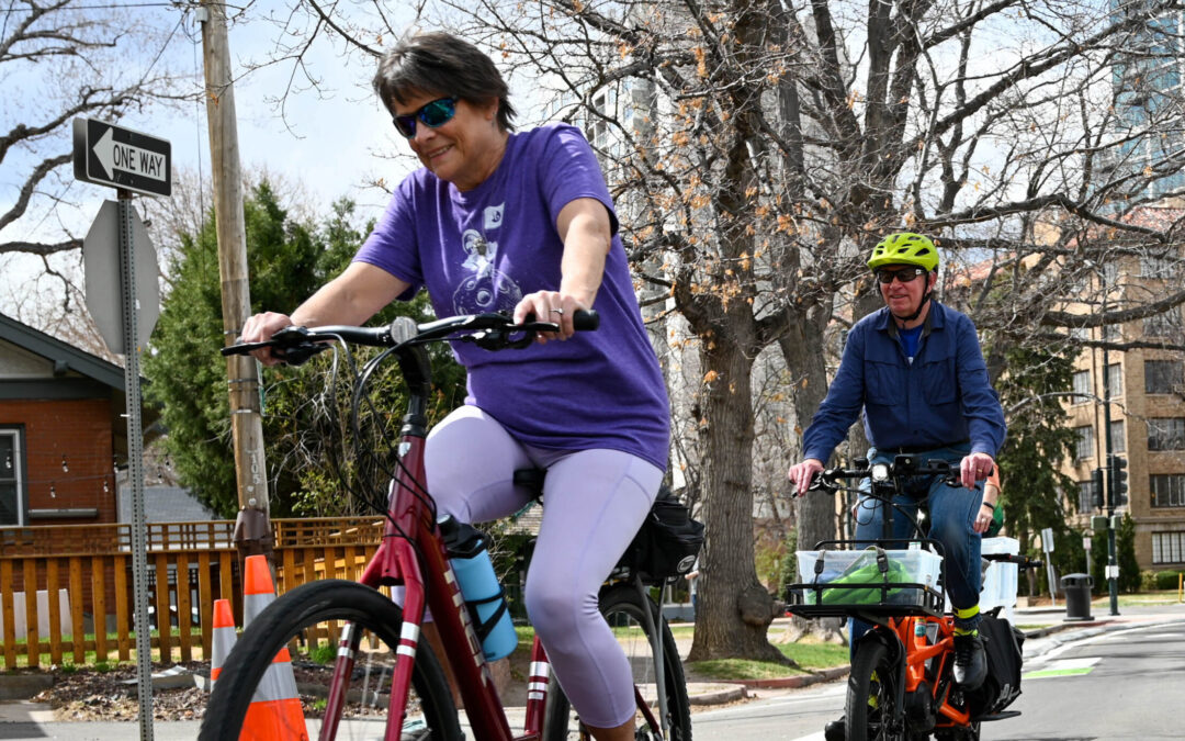 A man and a woman ride bicycles on Marion Parkway in Denver