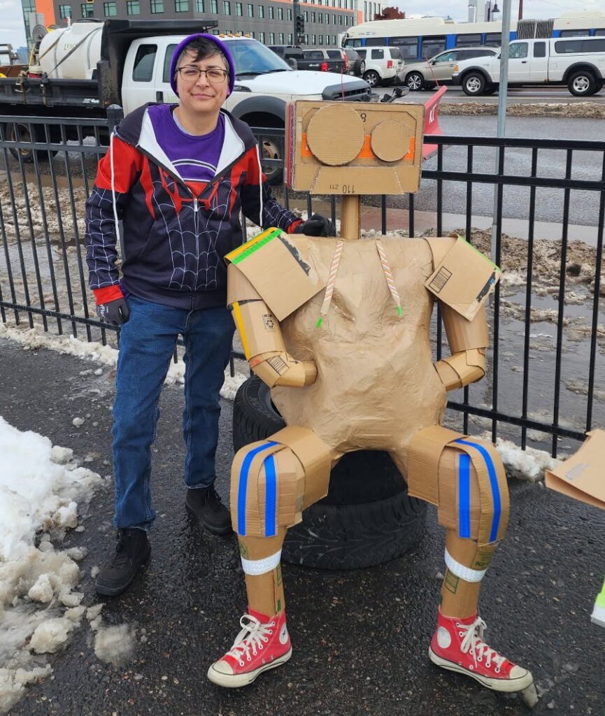 Artist Adelina Gonzales stands in front of her art piece installed at Federal Boulevard and 14th Ave