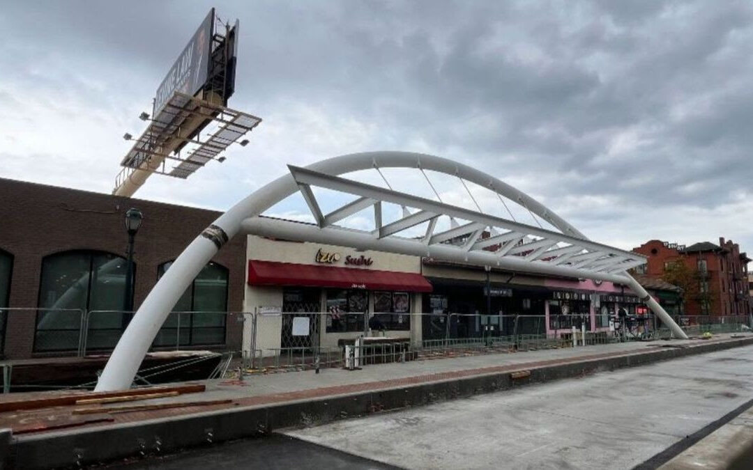 The newly installed arch on the eastbound Bus Rapid Transit (BRT) station platform at East Colfax Avenue and Franklin Street. At 21 feet tall and 87 feet long, the steel arch is easily seen and recognized from a distance and will provide shade and shelter from the elements for transit riders waiting for the BRT.